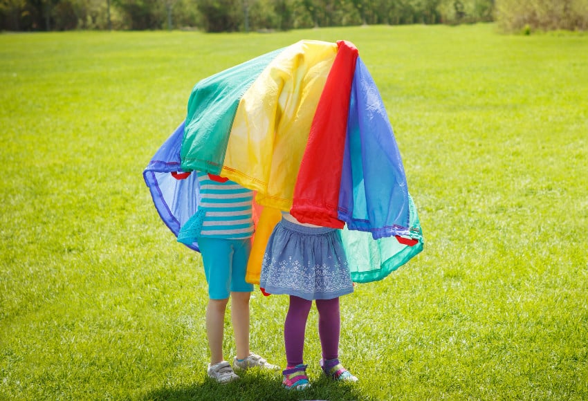 Children under a play parachute